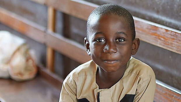 Junge auf Kirchenbank in Sierra Leone